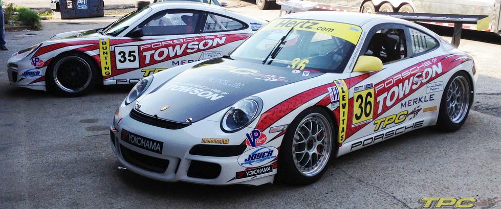 Two parked Porsche 997 GT3 cup cars with TPC Racing race livery